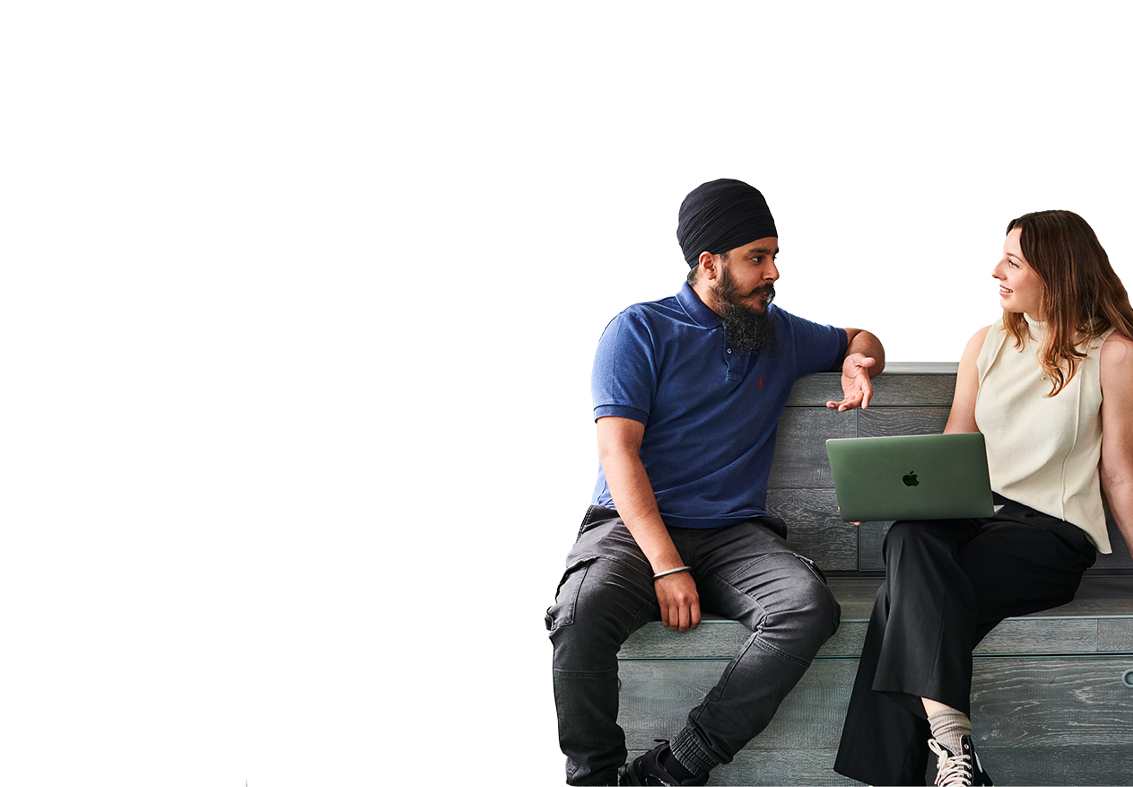 Two Deliveroo employees sitting on a sofa talking