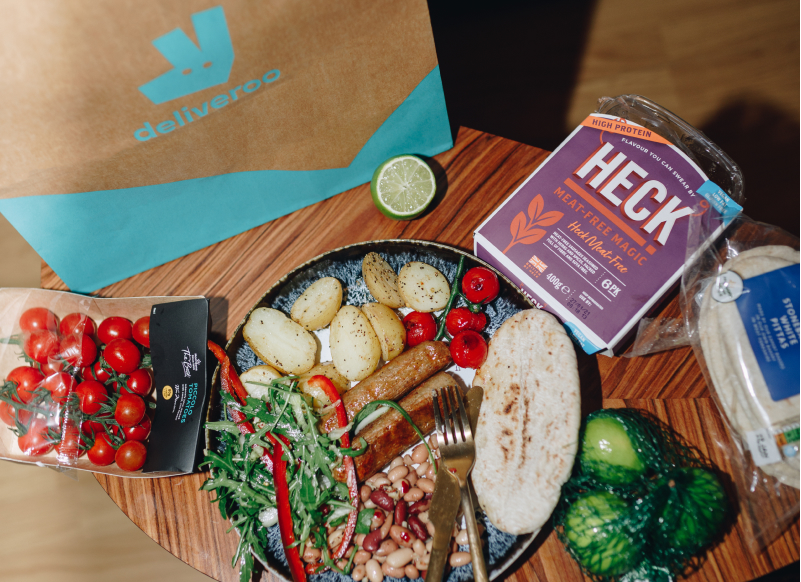 Deliveroo paper bag and a pile of vegetables