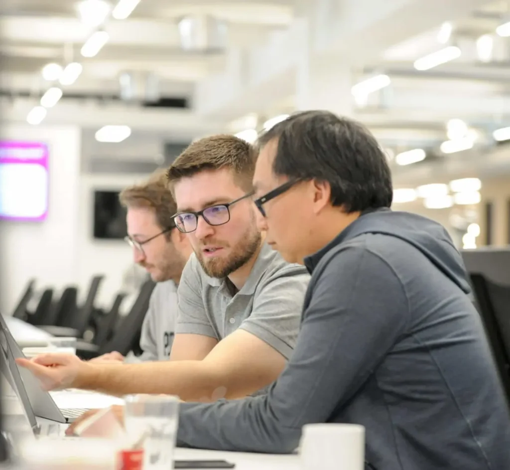 Two Deliveroo employees working at a laptop