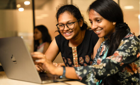 Two young women working at a laptop