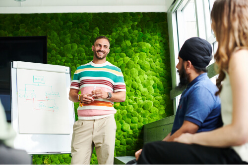 Deliveroo employee giving presentation in front of a flipchart to other employees