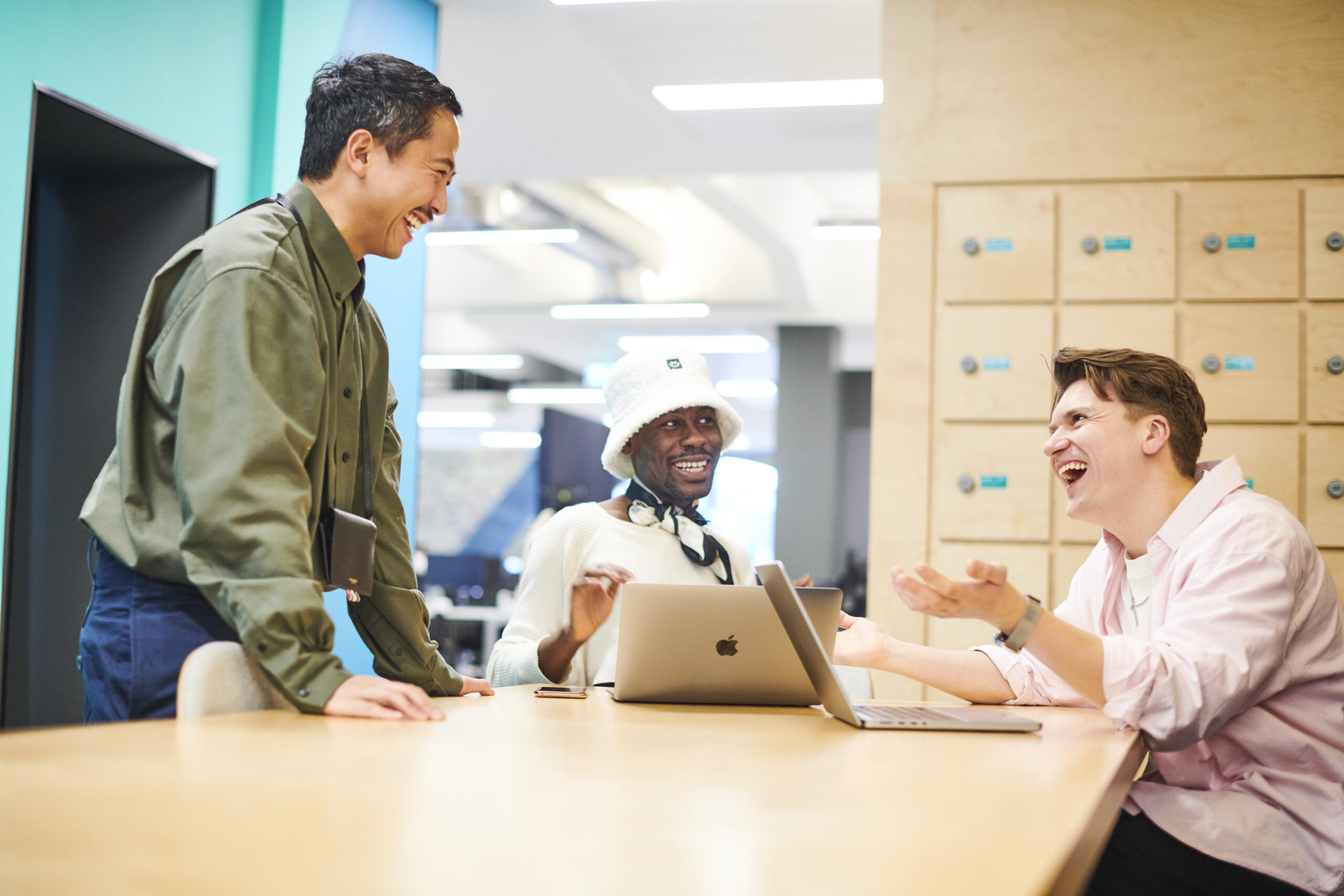 Three Deliveroo employees laughing together